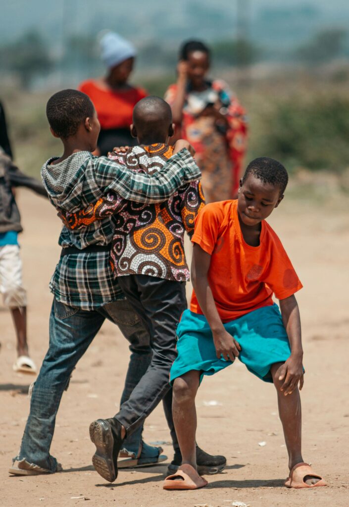 Group of children joyfully dancing outdoors, capturing the essence of fun and motion under the sunny sky.